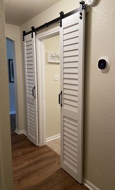 an open door with shutters in the hallway