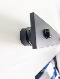 two black knobs are mounted on the wall