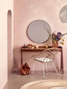 a room with a table, chair and mirror on it's wall next to a rug