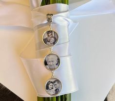 a bouquet with three pictures hanging from it's side next to a white ribbon