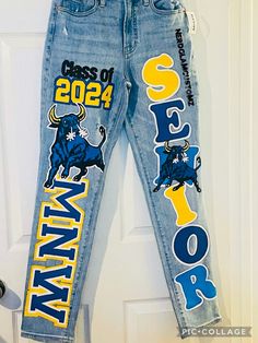 BUYER MUST PROVIDE THEIR OWN JEANS All artwork is hand painted. Design includes a total of 5 images on both pants legs.  Once payment is received, you will receive shipping address. Please allow 6 weeks for completion, starting from the date your jeans have been marked delivered. If you need it sooner, please message us to confirm availability. Rush fee $100 Homecoming Pants Idea, Senior Jeans Blue And Gold, Hoco Jeans Ideas, Homecoming Pants Ideas Sophomore, Homecoming Pants Decorated, Senior Spirit Jeans, Homecoming Jeans Decorated, Hoco Jeans Painted, Spirit Jeans Ideas