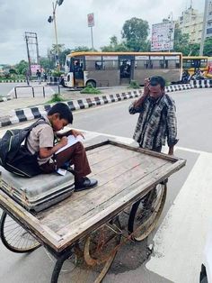 a man sitting on top of a wooden cart next to a person with a backpack