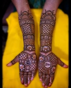 two hands with henna tattoos on them