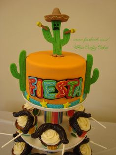 a birthday cake decorated with cupcakes and cactus on the top is for fiesta