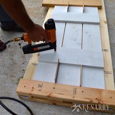 a person using a power drill to attach the boards