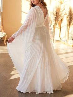 a woman in a white wedding dress posing for the camera