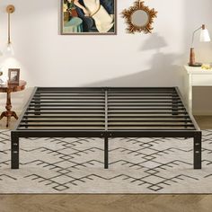 a metal bed frame sitting on top of a rug in a room with white walls