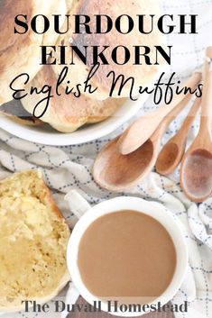 an english muffin and cup of coffee on a table with spoons next to it