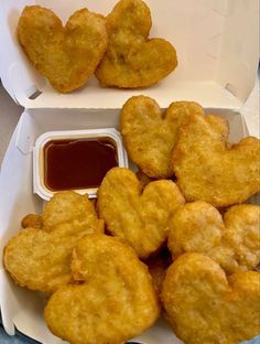 two takeout boxes filled with heart shaped fried food