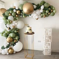 a room decorated with balloons, greenery and golds on the wall is shown