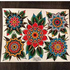 some colorful flowers on a white paper with green leaves and red, blue, yellow, orange