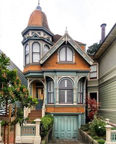 an old victorian style house painted in blue and orange