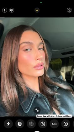 a woman with long hair sitting in a car