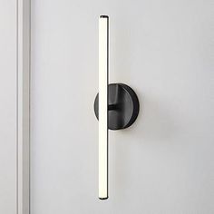 a black door handle on the side of a white door with a light in it