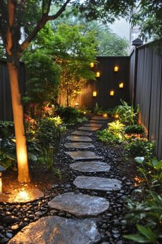 a stone path in the middle of a garden with trees and lights on each side