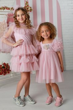 Introducing the girls' pink haze Brielle dress by the renowned designer brand OohLaLa Couture, available in sizes 12 months to 14 years. Designed with impeccable style, the Brielle dress boasts a trapezium neckline that exudes sophistication and a touch of uniqueness. The puff sleeves add a playful charm to the dress, making it a delightful choice for any occasion. The highlight of this dress is the exquisitely embroidered bodice, which showcases intricate craftsmanship and attention to detail. As your child twirls and moves, the dreamy tulle skirt of the Brielle dress dances with her, creating a whimsical and ethereal effect. The Brielle dress is versatile enough to be worn for various special occasions, from weddings to birthdays and beyond. It's a timeless addition to your wardrobe that Tulle Dress Short, New Cinderella, Embroidered Bodice, Pink Dresses, Feather Dress, Tea Parties, Dance Dresses, Hair Designs, Skirt Outfits