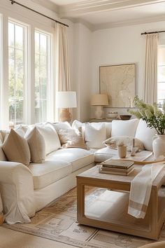 a living room filled with white furniture and lots of window sill space in front of them