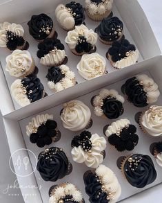 a box filled with cupcakes covered in white and black frosting