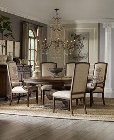 a formal dining room with chandelier and table in the center, chairs around it