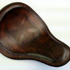 a brown leather seat on top of a white table with an intricate design in the center