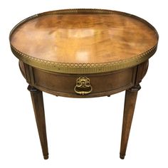 an oval wooden table with gold trimmings on the top and bottom, sitting against a white background