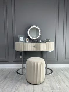 a dressing table with a mirror and stool in front of it on a wooden floor