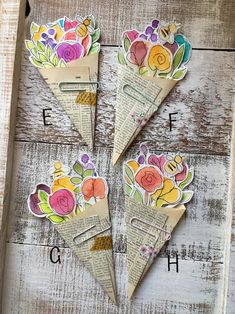 four pieces of paper with flowers on them are arranged in a triangle, and the letters e