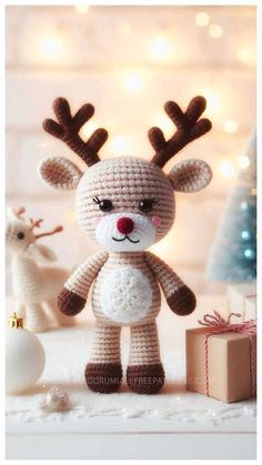 a crocheted reindeer is standing next to presents