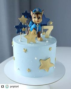 a blue cake with gold stars and a cartoon character on top