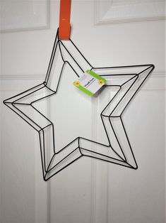 a metal star hanging on a door with a tag attached to it's side