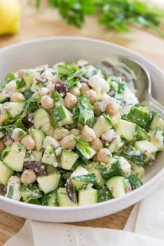 a white bowl filled with cucumber, chickpeas and feta cheese