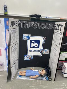 a display in the middle of a room with a doll laying on top of it