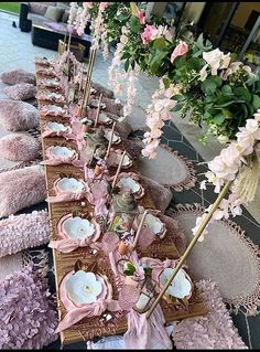 the table is set up with pink and white flowers in vases, plates, and napkins