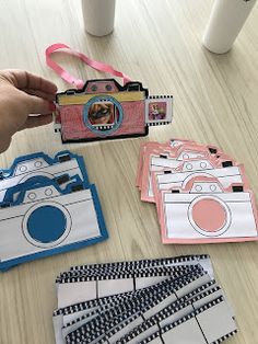 a person holding a camera next to some cards