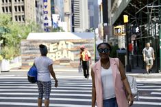 a woman crossing the street in front of some people