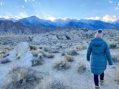 a person walking in the desert with mountains in the background