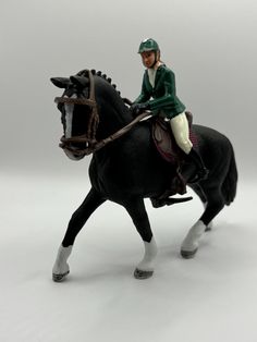 a toy man riding on the back of a black horse