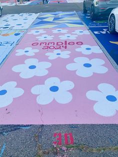 the sidewalk is decorated with flowers and has been painted pink, blue, and white