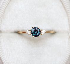 an engagement ring with a blue diamond surrounded by three diamonds