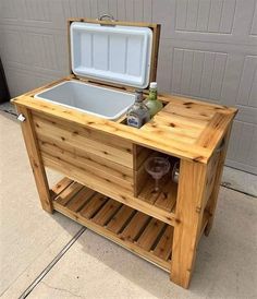 an ice chest with a cooler on the top and two drinks in it, sitting next to a garage door