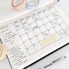 two rolls of washi tape sitting on top of a calendar next to some scissors