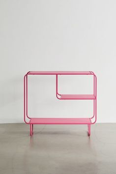 a pink shelf sitting on top of a cement floor