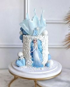 there is a cake decorated with an image of a frozen queen on it and decorations