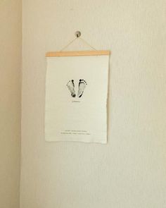 a white towel hanging on the wall with a pair of feet drawn on it's side