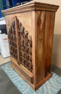 a wooden cabinet sitting on top of a blue rug