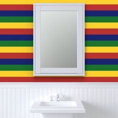 a bathroom sink sitting under a mirror next to a rainbow wallpapered wall behind it