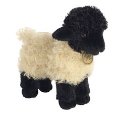 a black and white sheep stuffed animal with a tag on it's collar, standing upright