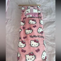 a pink hello kitty sleeping bag on a bed