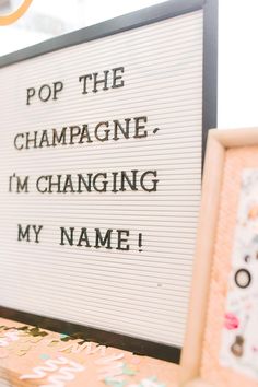 a sign that says pop the champagne, i'm changing my name on it