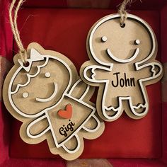 two wooden cutouts with the words john and girl on them hanging from twine